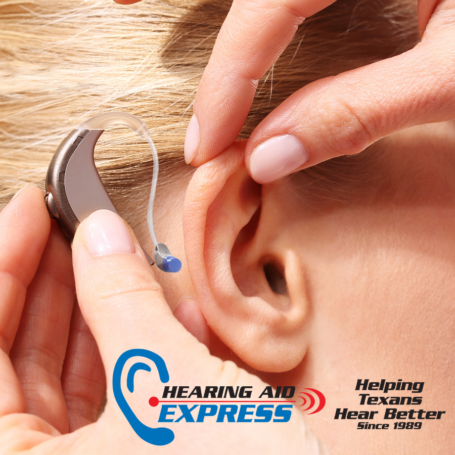A hearing aid being put into an ear.