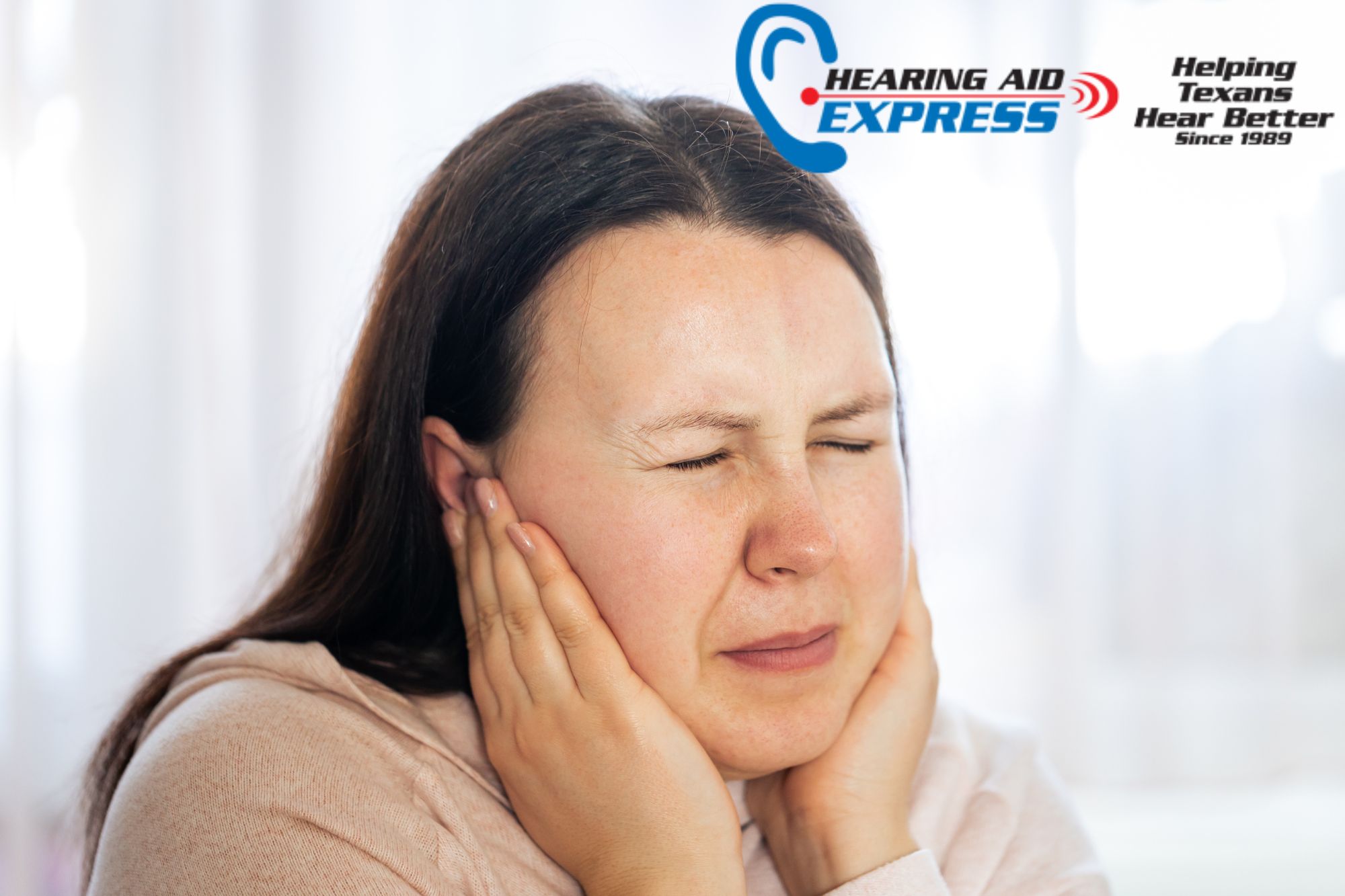 woman holding her ears in pain